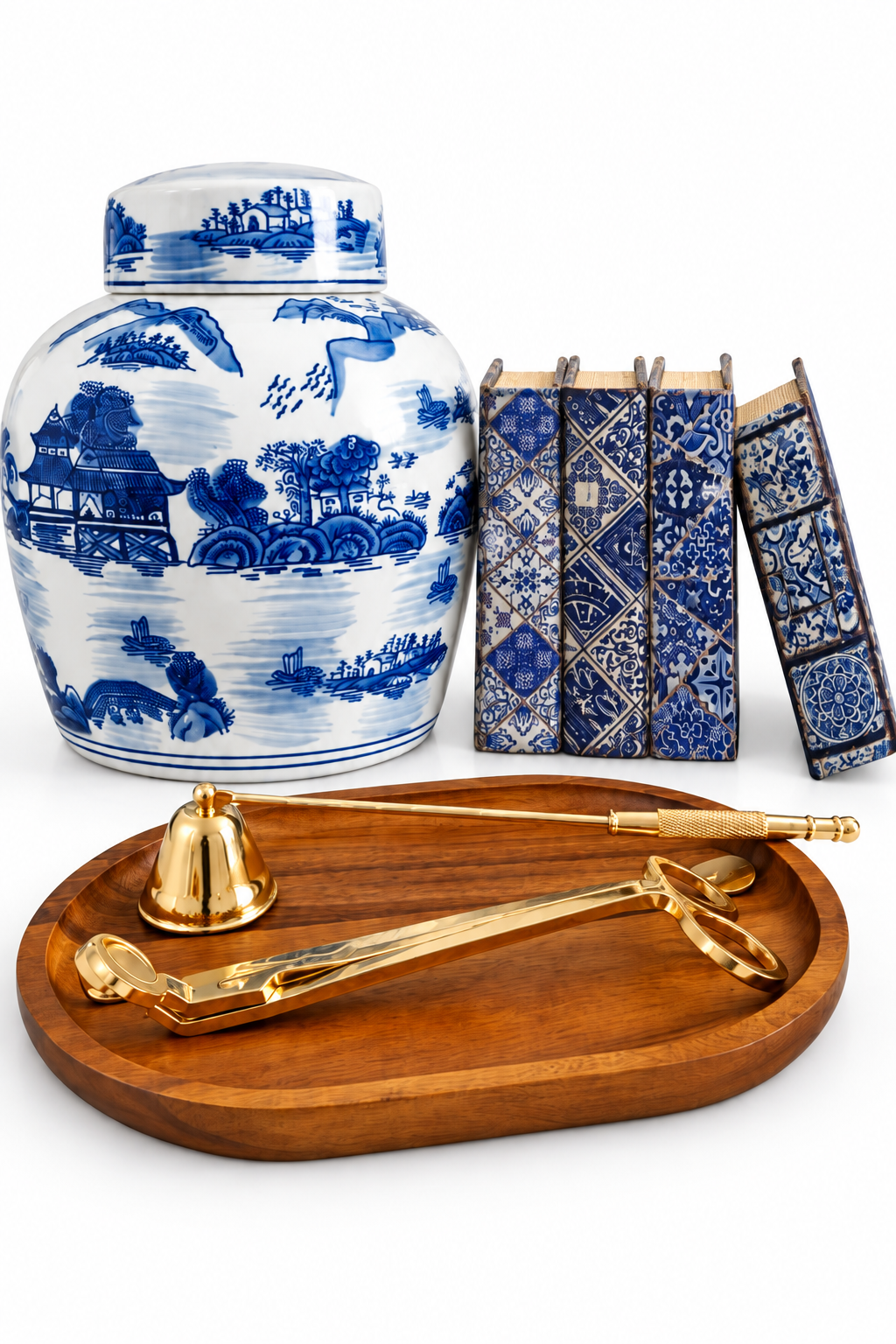 Blue and white chinoiserie ginger jar set with book boxes, acacia wood tray and gold-tone candle tools on a white background
